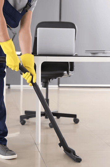 Cleaner vacuuming an office